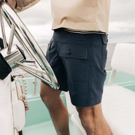 fit model driving a boat wearing The Trail Cargo Short in Faded Navy 60/40 Faille