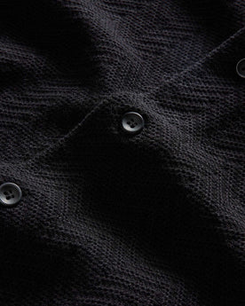 material shot of the buttons on The Button Down Polo in Coal Herringbone, Knits by Taylor Stitch