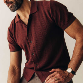 fit model sitting in The Button Down Polo in Dried Cherry Herringbone