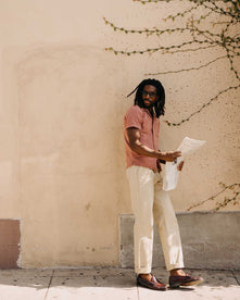 fit model leaning against the wall wearing The Conrad Shirt in Fired Brick Dobby