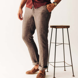 fit model standing next to a stool wearing The Easy Pant in Cocoa Linen