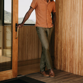 fit model leaning against the wall wearing The Easy Pant in Olive Linen