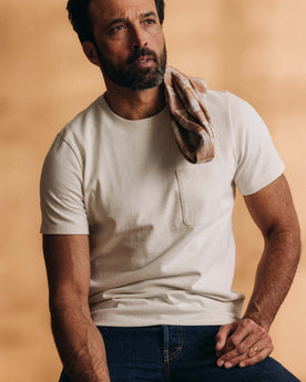 fit model sitting wearing The Heavy Bag Tee in Natural, Knits by Taylor Stitch