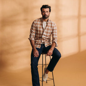 fit model sitting on a stool wearing The Jack in Baked Clay Plaid