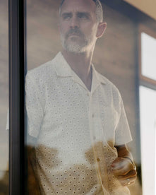 fit model looking through a window wearing The Short Sleeve Hawthorne in Vintage White Embroidered Eyelet