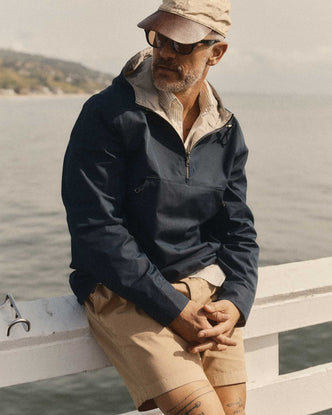 fit model leaning against a railing wearing The Squall Anorak in Navy Twill