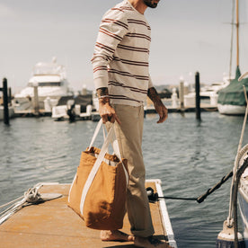 fit model standing on a dock in The Colton Crew in Oat Heathered Stripe
