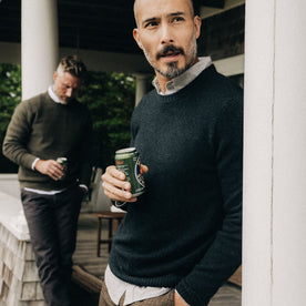 fit model holding a beer in The Lodge Sweater in Black Pine