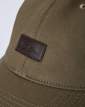 editorial image of the front tag on The Pathfinder Cap in Fatique Olive Dry Wax, Accessories by Taylor Stitch