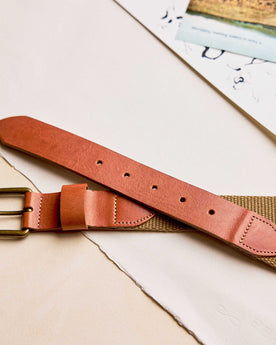 editorial image of The Webbed Belt in Whiskey on sheets of paper, Accessories by Taylor Stitch