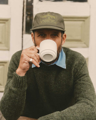 fit model sitting wearing The Mercer Cap in Fish Supply