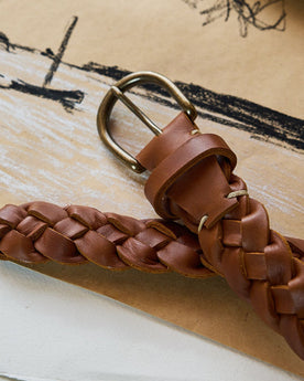 editorial image of the buckle of The Braided Belt in Whiskey on a piece of paper, Accessories by Taylor Stitch
