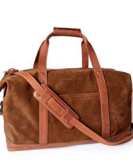 flatlay of The Weekender Duffle in Chocolate Roughout, Accessories by Taylor Stitch