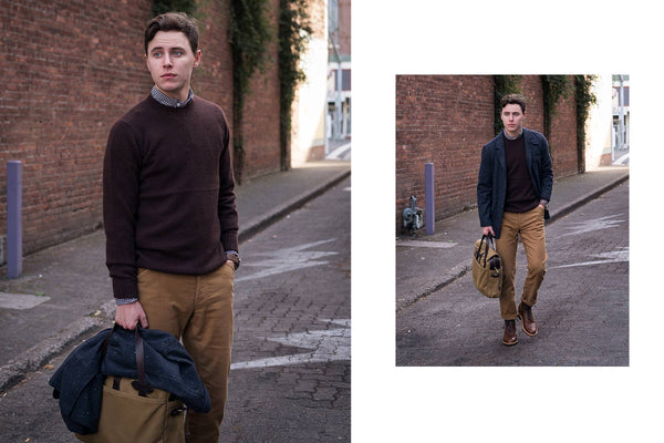 John carrying a messenger bag, walking down a cobbled street.