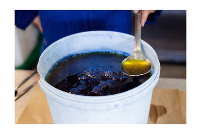 a process shot of the indigo dye in a vat and spoon