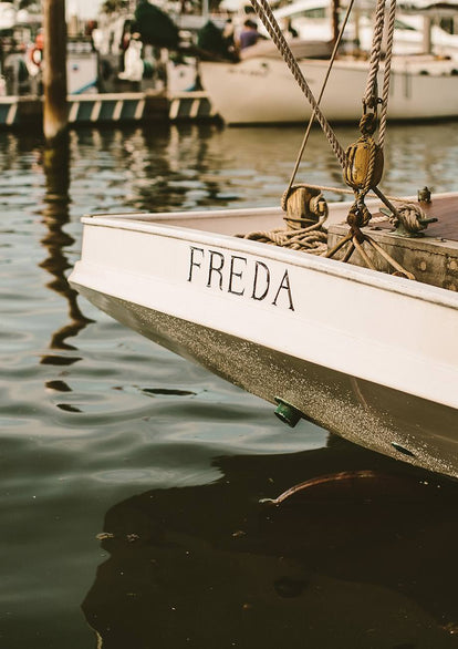 The stern of a wooden yacht named 'Freda'.