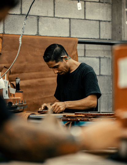 A craftsman at work, obscured by machinery and tools.