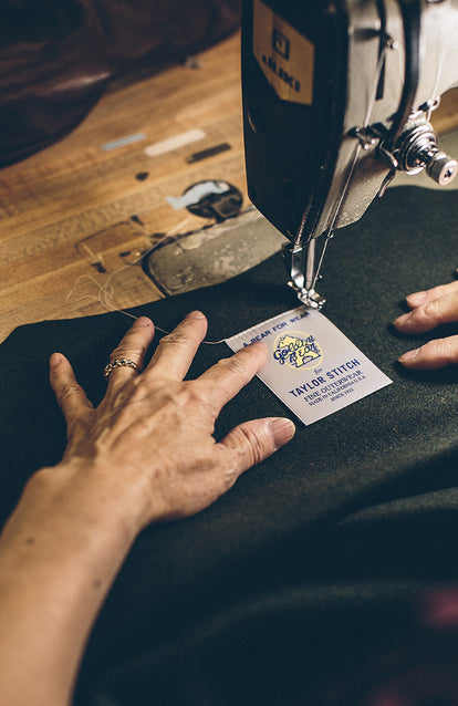 The Golden Bear label being stitched into a garment.