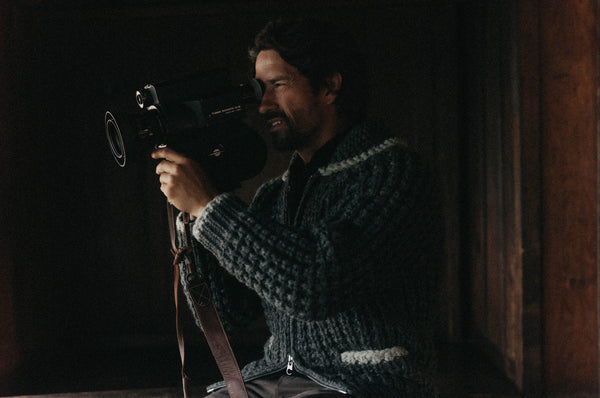 The Seawall Sweater hanging on a wooden wall