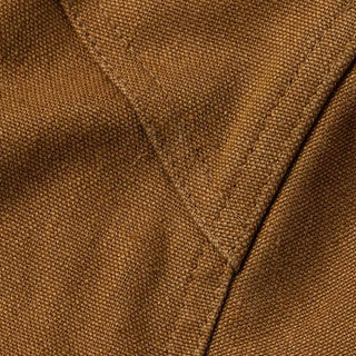 Closeup image of the seams on a pair of camel-colored canvas pants.