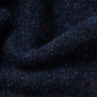 Closeup image of navy blue yak wool with flecks of red, royal blue, and white.