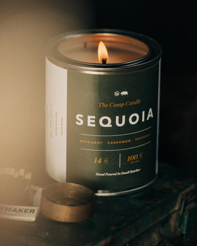 material shot of flatlay of The Camp Candle in Sequoia on a table, Accessories by Taylor Stitch