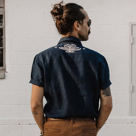 fit model facing the back in The Embroidered Short Sleeve Western in Indigo Linen
