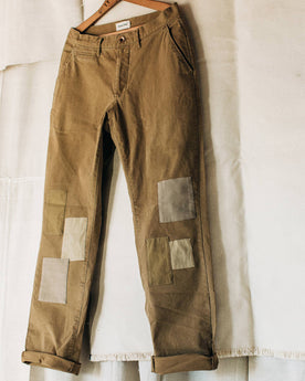 material shot of The Atelier and Repairs Chino in British Khaki, hanging in studio, Bottoms by Taylor Stitch