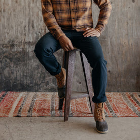 fit model wearing The Camp Pant in Coal Boss Duck, sitting on stool