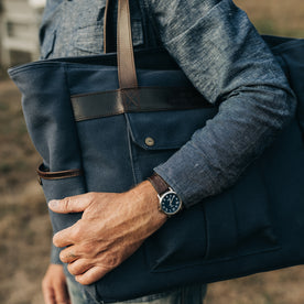 fit model holding The Utility Bag in Navy