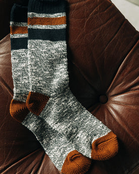 fatlay of The Camp Sock in Heather Olive on a couch, Accessories by Taylor Stitch