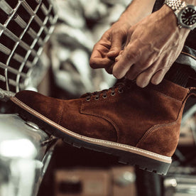 fit model tying the shoelaces on The Moto Boot in Snuff Weatherproof Suede