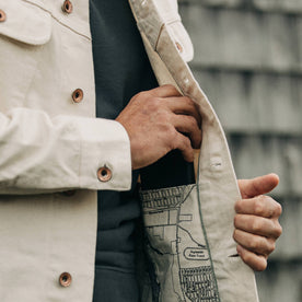 fit model wearing The Long Haul Jacket in Natural Organic Selvage, putting phone in pocket, detail shot