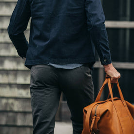 fit model wearing The Morse Pant in Charcoal Slub Linen, back shot holding bag