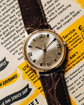 flatlay of the 1969 Timex Marlin, on an old magazine, Accessories by Taylor Stitch