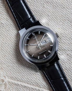 flatlay of the 1977 Timex Marlin M106 on a white cloth background, Accessories by Taylor Stitch