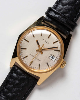 flatlay of the 1978 Timex Gold Marlin, shown close up, Accessories by Taylor Stitch