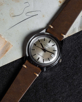 flatlay of the 1978 Timex Viscount M108 against a graphite background, Accessories by Taylor Stitch