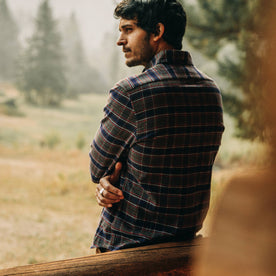 fit model wearing The Jack in Brushed Grey Plaid, sitting against house
