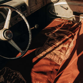 The Golden State Blanket in Rust laying alongside a seat in a vintage car | fit model