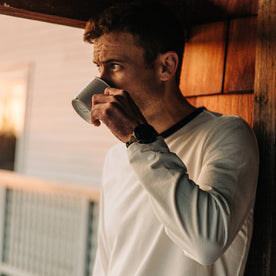 fit model wearing The Heavy Bag Long Sleeve in Natural, drinking coffee cropped