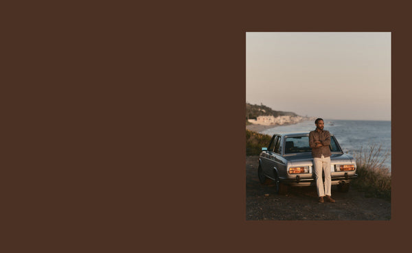 Model standing next to vintage bmw by the ocean
