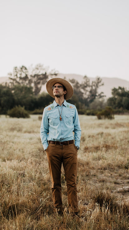 Daren Magee looking up while standing in a field while wearing our collaboration pieces