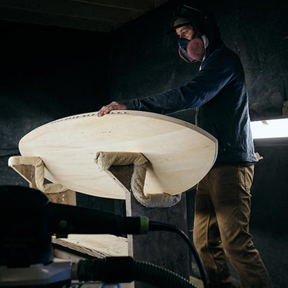 Man sanding the surfboard of our collaboration