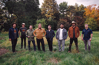 Nathaniel Rateliff and the Nightsweats standing in a field wearing our collaboration pieces