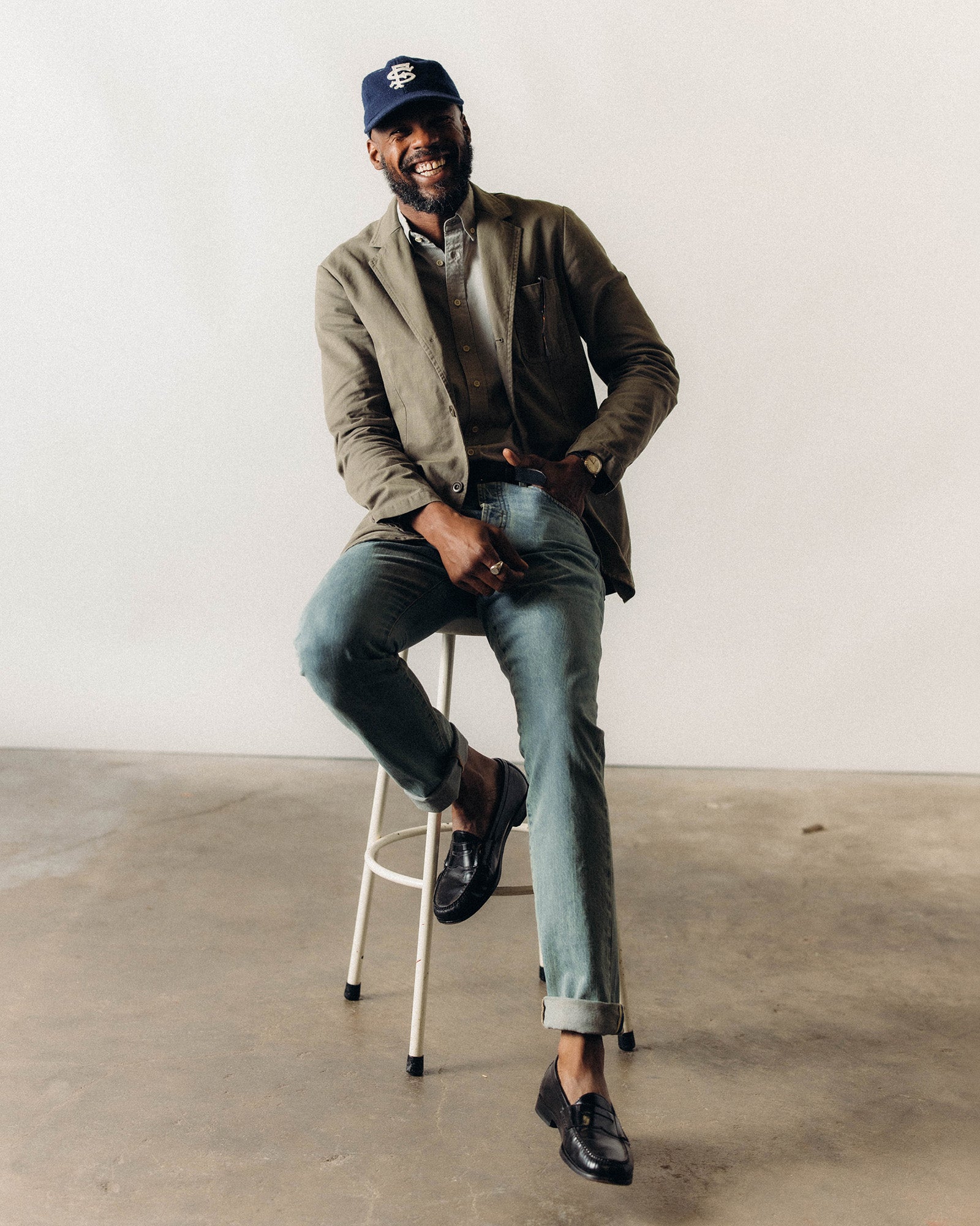 fit model leaning against a bar wearing The Foundation Sportcoat in Organic Smoked Olive Twill, Outerwear by Taylor Stitch