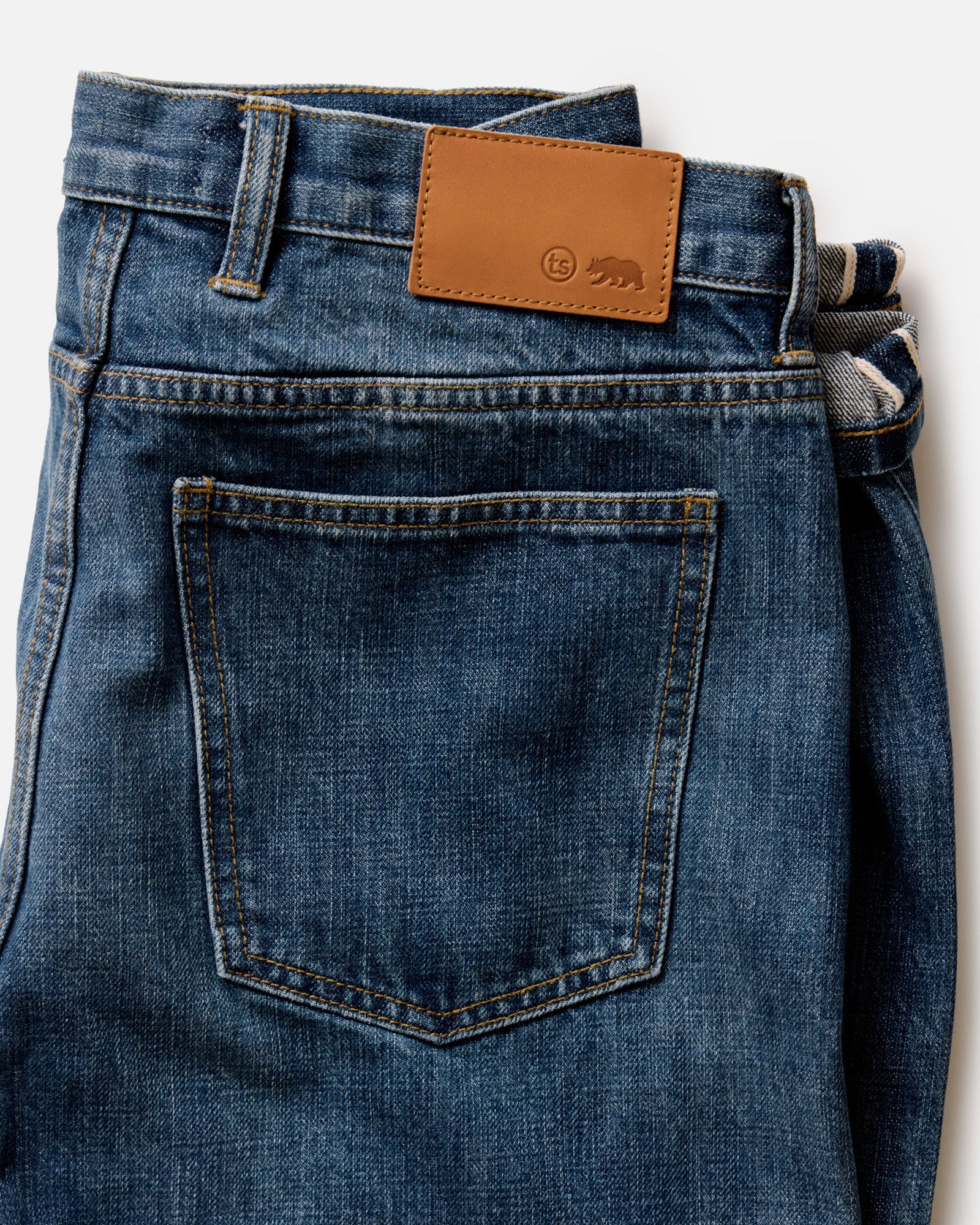 folded flatlay of the back of The Slim Jean in Mid Wash Organic Selvedge, Bottoms by Taylor Stitch