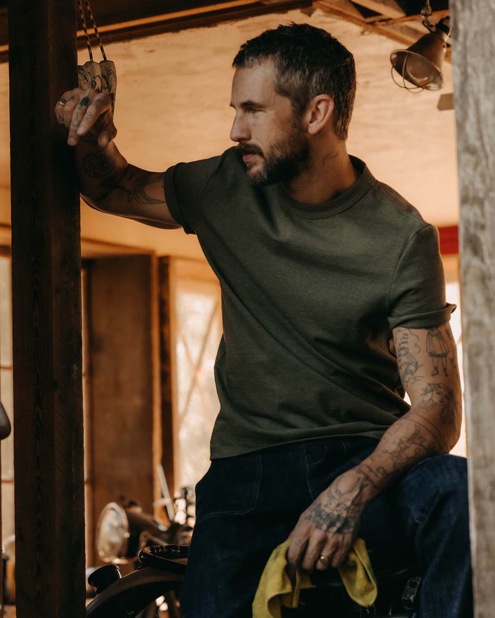 fit model sitting wearing The Organic Cotton Shop Tee in Army Twist, Knits by Taylor Stitch