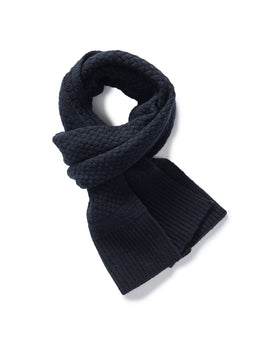 editorial image of The Textured Knit Scarf in Heather Navy Merino rolled up, Accessories by Taylor Stitch