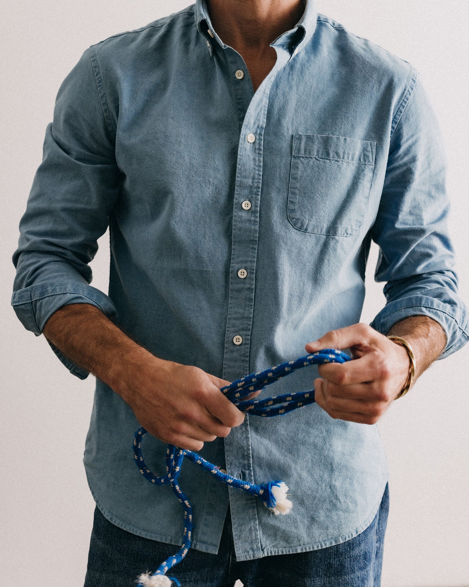 fit model leaning against the wall wearing The Jack in Washed Indigo Oxford, Wovens by Taylor Stitch